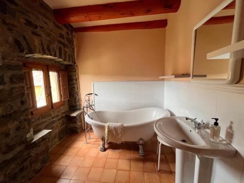 a bathroom with a bath tub and a sink at La Abadia in Coscojuela de Sobrarbe