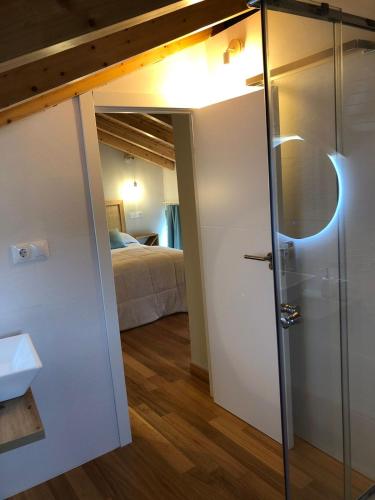 een kamer met een bed en een badkamer met een deur bij Apartamentos El Arroyo in Armal