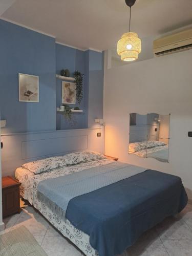 Un dormitorio con una cama y una pared azul. en La botteguccia, en Scilla