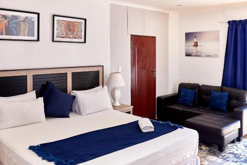 um quarto com uma cama grande e uma cadeira em Airport Royal Guest House em Kempton Park