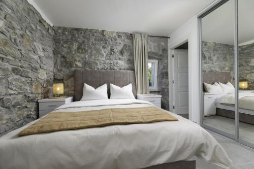 1 dormitorio con 1 cama grande y pared de piedra en Luxury 5 stars villa Berisha en Krk