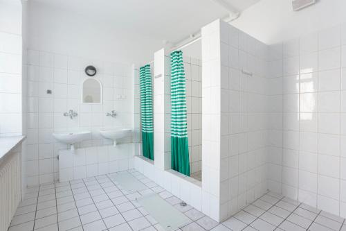 baño con lavabo y 2 espejos en Dizzy Daisy Hostel, en Wroclaw