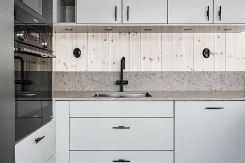 a kitchen with white cabinets and a sink at Charming cottage in Vemdalen near skiing in Vemdalen