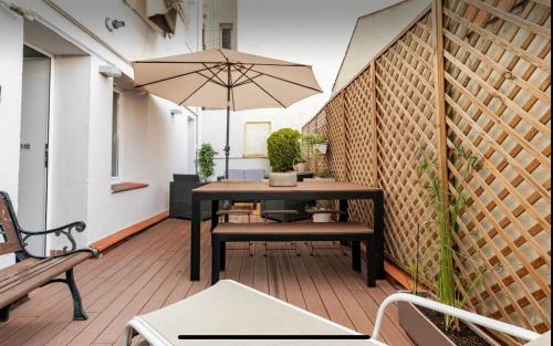 a patio with a table and a bench and an umbrella at Habitación Simple en PISO COMPARTIDO C in Madrid