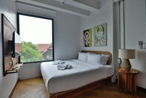 - une chambre avec un grand lit blanc et une fenêtre dans l'établissement KWANS Ayutthaya, à Phra Nakhon Si Ayutthaya