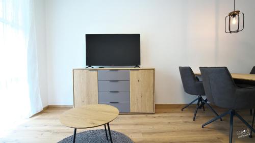 a living room with a tv and two chairs at Landhaus Seppenbauer in Bad Ischl