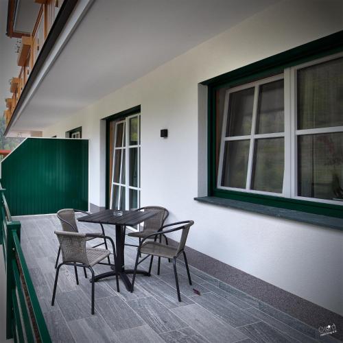 a table and chairs on a porch with a window at Landhaus Seppenbauer in Bad Ischl