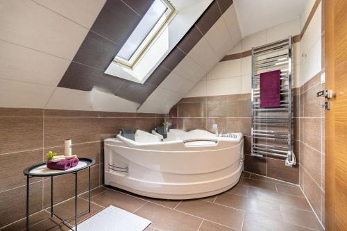 a bathroom with a tub and a sink and a skylight at Stylový dům Chlumec in Chlumec