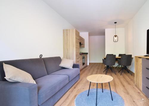 a living room with a blue couch and a table at Landhaus Seppenbauer in Bad Ischl