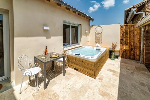 a backyard with a hot tub and a table and chairs at l'Alcove - SPA&SAUNA privé - Oliveraie d'Eurocentre in Castelnau-dʼEstrétefonds