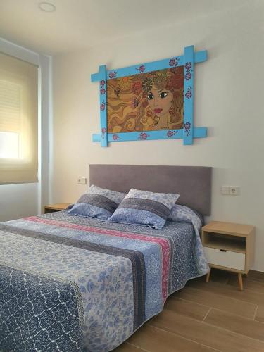 a bedroom with a bed with a picture on the wall at Apartamento a estrenar en Planta Primera C con piscina in Barbate