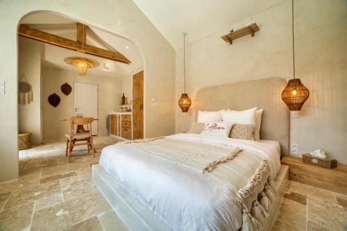 a bedroom with a large white bed and a table at l'Alcove - SPA&SAUNA privé - Oliveraie d'Eurocentre in Castelnau-dʼEstrétefonds