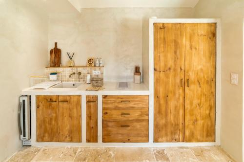 a kitchen with a sink and a wooden cabinet at l'Alcove - SPA&SAUNA privé - Oliveraie d'Eurocentre in Castelnau-dʼEstrétefonds