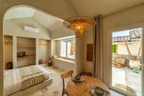Schlafzimmer mit einem Bett, einem Tisch und einem Fenster in der Unterkunft l'Alcove - SPA&SAUNA privé - Oliveraie d'Eurocentre in Castelnau-dʼEstrétefonds