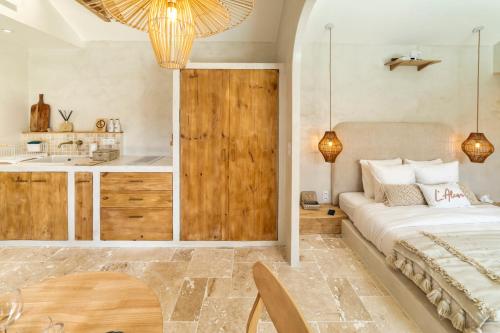 a bedroom with a bed and a kitchen with a sink at l'Alcove - SPA&SAUNA privé - Oliveraie d'Eurocentre in Castelnau-dʼEstrétefonds