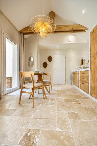 a dining room with a table and a chandelier at l'Alcove - SPA&SAUNA privé - Oliveraie d'Eurocentre in Castelnau-dʼEstrétefonds