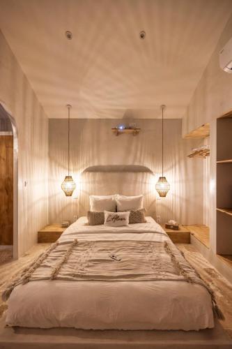 a bedroom with a large bed with two lamps at l'Alcove - SPA&SAUNA privé - Oliveraie d'Eurocentre in Castelnau-dʼEstrétefonds