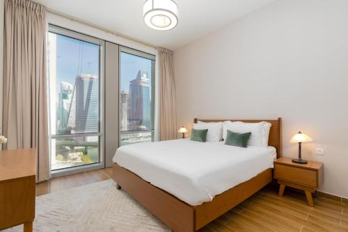 a bedroom with a large bed and a large window at White Sage - Amna Tower in Dubai