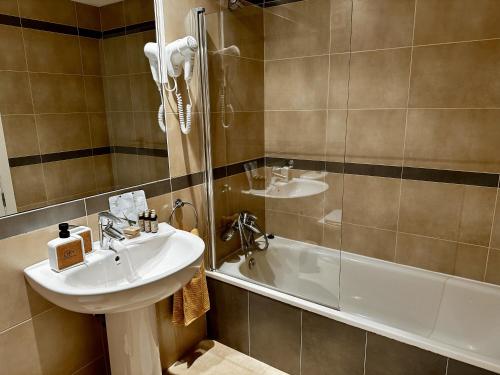 een badkamer met een wastafel, een douche en een bad bij Esmeralda Suites in Calpe