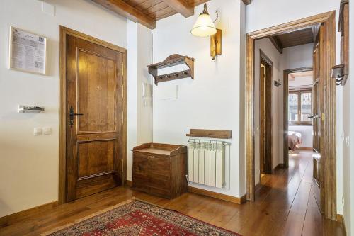 um corredor com uma porta de madeira e um tapete em Luderna - Apartamento Centelha em Tredós