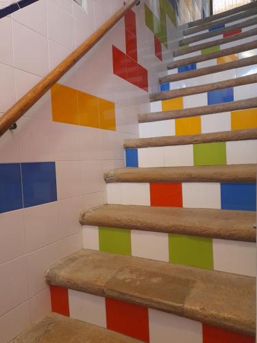 a staircase with a colorful wall at Rose Rooms in Faro