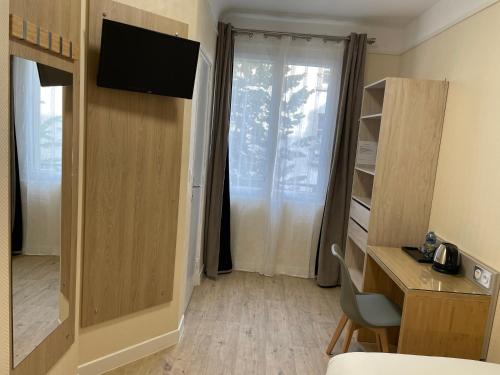 Cette chambre dispose d'une porte, d'une télévision et d'un bureau. dans l'établissement Residence Hoche, à Le Pré-Saint-Gervais