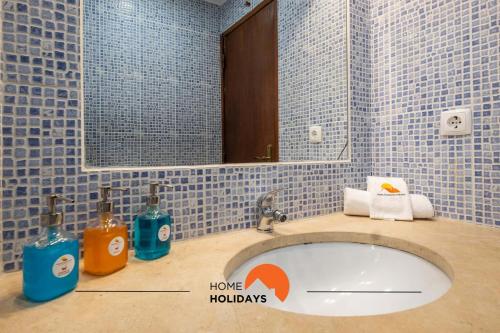 La salle de bains est pourvue d'un lavabo, d'un miroir et de carrelage bleu. dans l'établissement #027 Center City with Pool, High Speed Wifi, à Albufeira