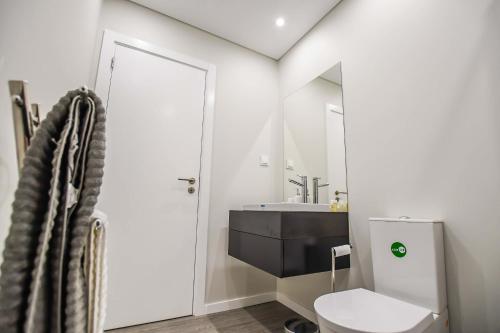 een badkamer met een wit toilet en een wastafel bij Solar da Rochinha Magnifico Apt 2 Quartos Funchal in Funchal
