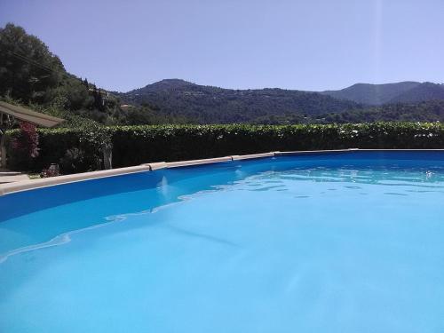 une grande piscine bleue avec des montagnes en arrière-plan dans l'établissement VILLA DE CHARME sur la Côte d'Azur, à Tourrette-Levens