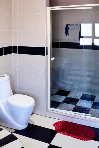 a bathroom with a toilet and a glass shower at Airport Royal Guest House in Kempton Park