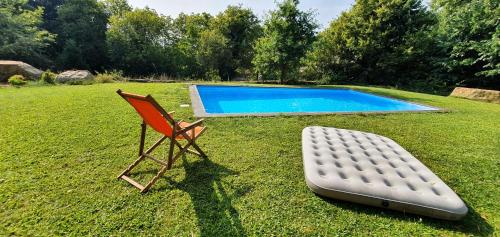 una silla y un colchón junto a una piscina en Casa Blé Marco de Canaveses, en Marco de Canaveses