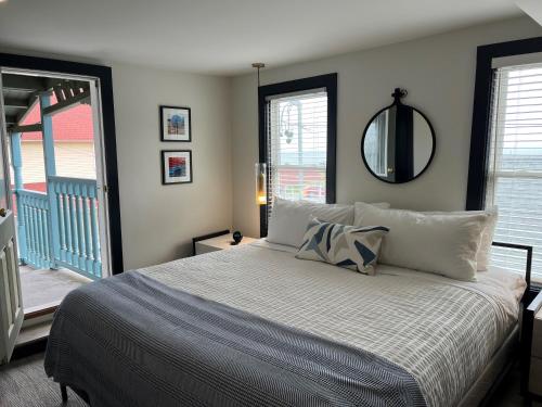um quarto com uma cama com um espelho na parede em The Morgan Hotel Martha's Vineyard em Oak Bluffs