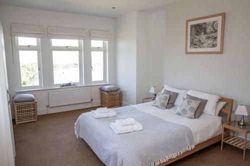 a bedroom with a bed with towels on it at Island View at White Horses, Bantham, South Devon - with glorious sea views in Bigbury on Sea