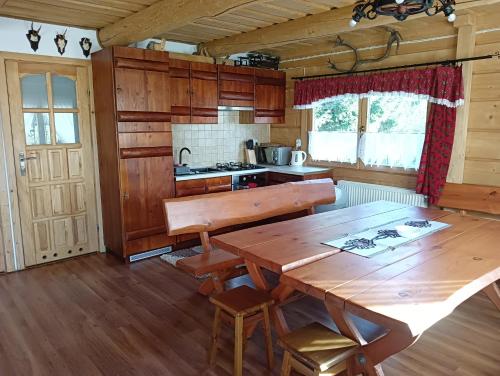 a kitchen with a wooden table in a room at Domek góralski Toporówka in Murzasichle