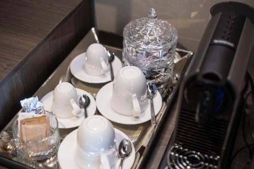 a tray with cups and saucers in a room at Hotel Vinifera Wine & Spa 5 Stars Superior in Balatonfüred