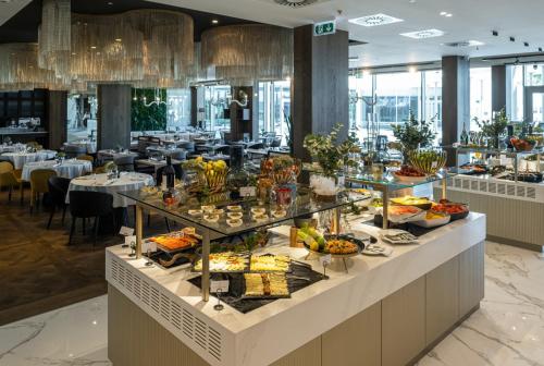a buffet in a restaurant with food on display at Hotel Vinifera Wine & Spa 5 Stars Superior in Balatonfüred