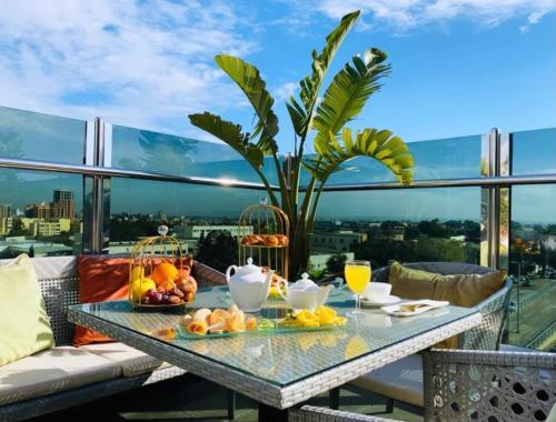 a table with fruit on a balcony with a view at Rodina hôtel spa & conferences in Oran
