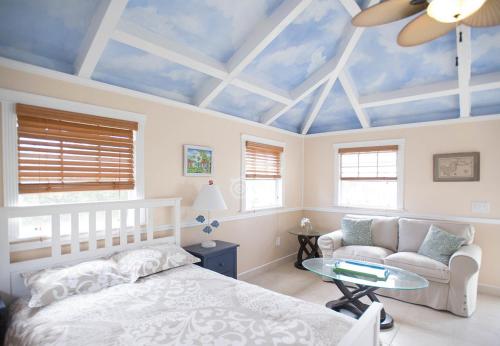 1 dormitorio con cama blanca y techo azul en Bungalows On The Bay en Christiansted