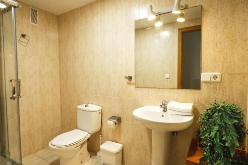 a bathroom with a toilet and a sink and a mirror at Apartamentos Magic Atrium Plaza in Benidorm