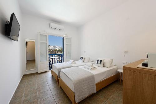 a hotel room with two beds and a television at Hotel Bilia in Naousa