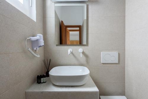 a bathroom with a white sink and a mirror at Hotel Bilia in Naousa