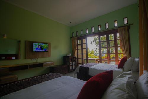 a hotel room with two beds and a television at VILLA IPSA in Munduk