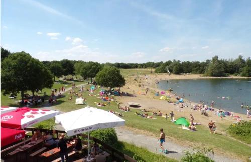 a crowd of people on a beach with a lake at Rheinländer Seehotel in Leverkusen