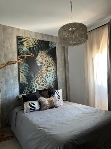 a bedroom with a bed with a painting of a leopard at Real de la Barrosa in Chiclana de la Frontera