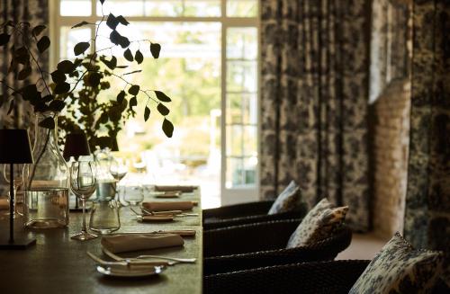 uma sala de jantar com uma mesa com cadeiras e uma janela em COMO Le Montrachet em Puligny-Montrachet