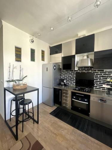 Il dispose d'une grande cuisine avec une table et un réfrigérateur. dans l'établissement T3 moderne et climatisé - Plages à pied - PARKING GRATUIT, à Vallauris