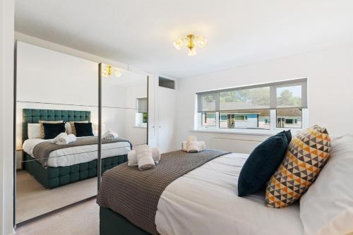 ein Schlafzimmer mit zwei Betten und einem großen Spiegel in der Unterkunft Merlins Gardens in Tenby