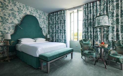 a bedroom with a bed and a chair and a window at COMO Le Montrachet in Puligny-Montrachet