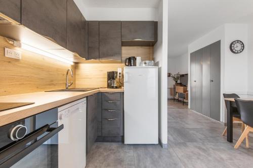 une cuisine avec un réfrigérateur blanc et une table dans l'établissement SouthMarina by POM, vue bateaux, terrasse, parking, au Cap d'Agde