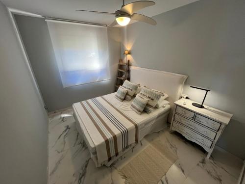 a small white bedroom with a bed and a table at Playa Romana Altamar in Alcossebre